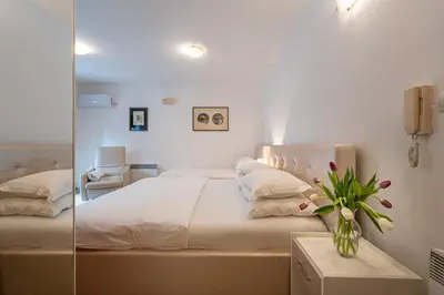 a bedroom with a large bed and a mirror at Maslina Residence in Budva