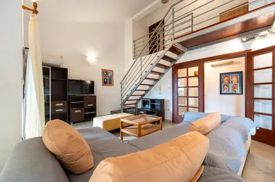 a living room with a couch and a staircase at Maslina Residence in Budva