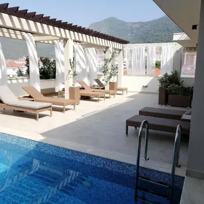 a resort pool with lounge chairs and a swimming pool at Apartments and Rooms Grand Palazzo in Budva