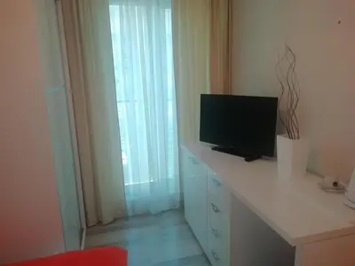 a room with a desk with a television on it at Apartments and Rooms Grand Palazzo in Budva