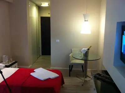 a room with a bed and a table and a television at Apartments and Rooms Grand Palazzo in Budva
