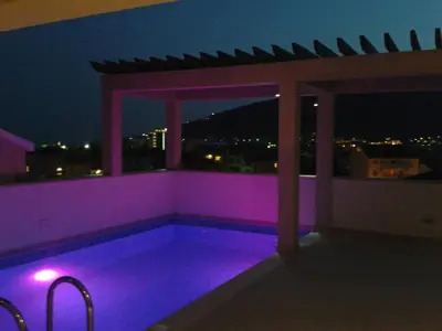 a swimming pool with purple lighting on a balcony at night at Apartments and Rooms Grand Palazzo in Budva