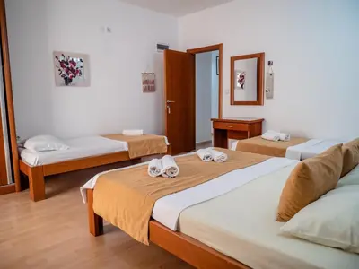 a room with three beds and a mirror at Apartments Bonita in Ulcinj