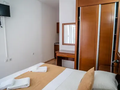 a bedroom with a bed and a dresser and a mirror at Apartments Bonita in Ulcinj