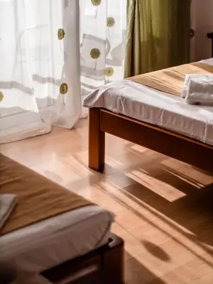 a bedroom with two beds and a wooden floor at Apartments Bonita in Ulcinj