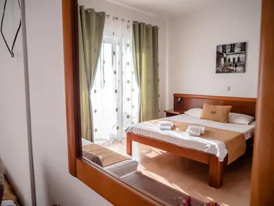 a reflection of a bedroom with a bed in a mirror at Apartments Bonita in Ulcinj