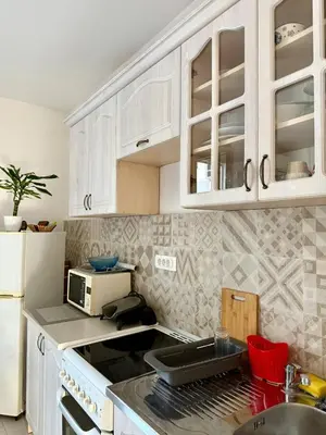 a kitchen with white cabinets and a stove top oven at Center Oasis Retreat in Podgorica