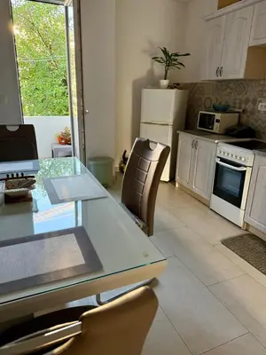 a kitchen with a glass table and chairs in it at Center Oasis Retreat in Podgorica