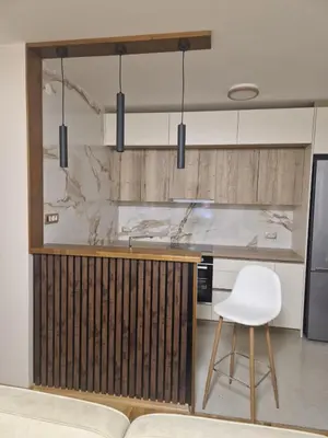 a kitchen with a counter and a white chair at City Haven Deluxe in Podgorica