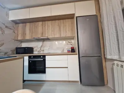 a kitchen with white cabinets and a stainless steel refrigerator at City Haven Deluxe in Podgorica