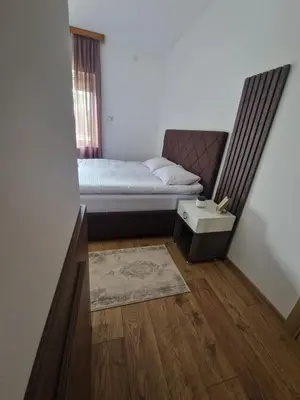 a small bedroom with a bed and a rug at City Haven Deluxe in Podgorica