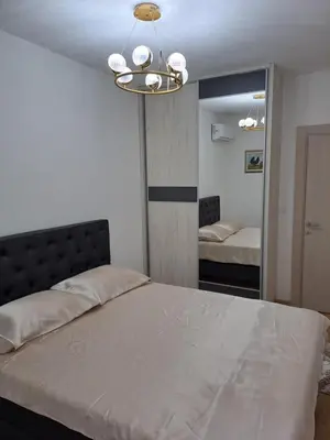 a bedroom with a large bed and a mirror at Apartman Podgorica Vlado 1 in Podgorica