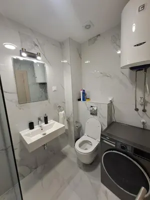 a white bathroom with a toilet and a sink at Apartman Podgorica Vlado 1 in Podgorica