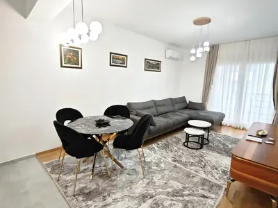 a living room with a couch and a table and chairs at Apartman Podgorica Vlado 1 in Podgorica