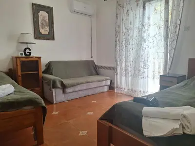 a room with two beds and a couch and a window at Apartments at Villa with swimming pool&parking in Budva