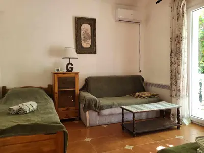 a living room with a couch and a table at Apartments at Villa with swimming pool&parking in Budva