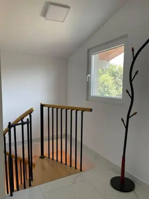 a staircase with a window and a tree in a room at Private house in the Capital City of Montenegro in Podgorica
