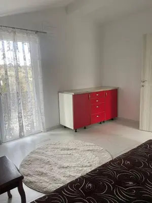 a living room with a red dresser and a window at Private house in the Capital City of Montenegro in Podgorica
