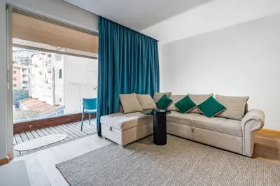 a living room with a couch and a large window at Status-M Apartments Nexsan1 in Budva