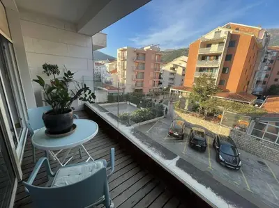 a balcony with a table and chairs and a window at Status-M Apartments Nexsan1 in Budva