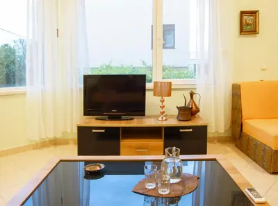 a living room with a tv and a couch at Villa Rossa in Utjeha