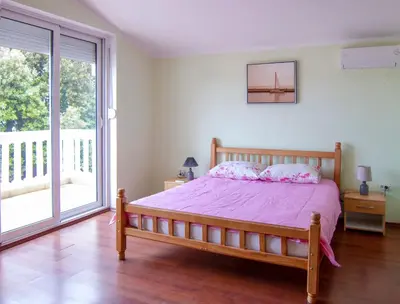 a bedroom with a bed and a large window at Villa Rossa in Utjeha