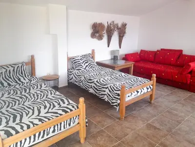 a living room with two beds and a red couch at Villa Rossa in Utjeha