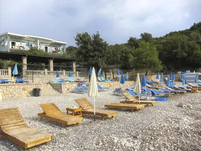 a group of lounge chairs and umbrellas on a beach at Villa Rossa in Utjeha