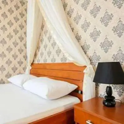 a bed with a white pillow and a table with a lamp at Apartments Taida in Dobra Voda
