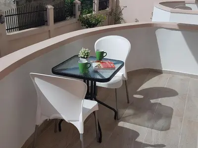 a table and two chairs sitting next to a pool at Apartments Taida in Dobra Voda