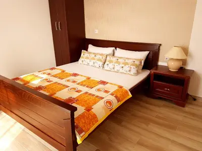 a bedroom with a large bed with a wooden floor at Apartments Taida in Dobra Voda