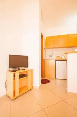 a kitchen with a flat screen tv on a table at Apartments Taida in Dobra Voda