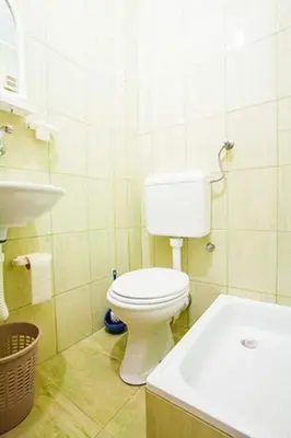 a bathroom with a white toilet and a sink at Apartments Taida in Dobra Voda