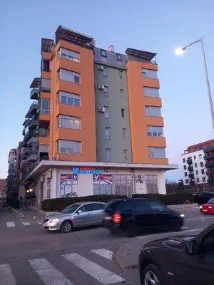 a tall building with cars parked in front of it at Apartment near hospital Podgorica in Podgorica