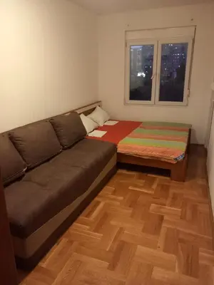 a living room with a couch and a window at Apartment near hospital Podgorica in Podgorica