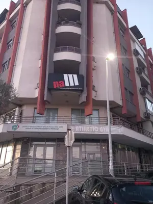 a building with a car parked in front of it at Apartment near hospital Podgorica in Podgorica