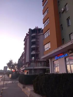 a building with a sign on it next to a street at Apartment near hospital Podgorica in Podgorica