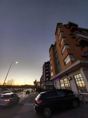 a parking lot with cars parked in front of a building at Apartment near hospital Podgorica in Podgorica