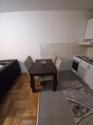 a small kitchen with a table and a stove at Apartment near hospital Podgorica in Podgorica
