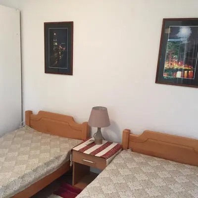 a bedroom with two beds and a lamp on a table at Apartment Cats in Utjeha