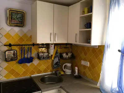a kitchen with white cabinets and a sink at Apartment Cats in Utjeha