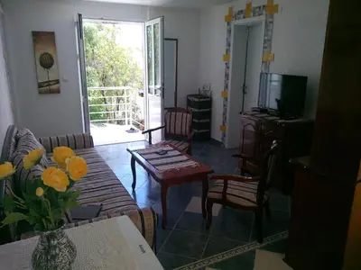 a living room with a couch and a table and chairs at Apartment Cats in Utjeha