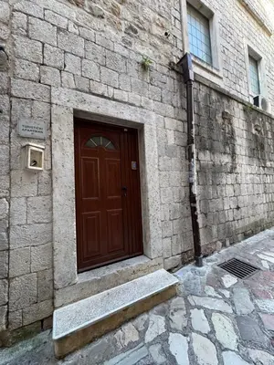 a brown door on a brick building with a stairs at Vita Mundo in Kotor