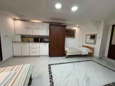 a kitchen with white cabinets and a bed in it at Vita Mundo in Kotor