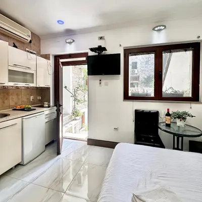 a kitchen with a bed and a table in a room at Vita Mundo in Kotor
