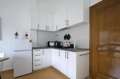 a kitchen with white cabinets and a white refrigerator at Status-M Apartments Seoce 26 in Budva