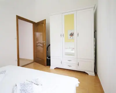 a white bedroom with a bed and a mirror at Status-M Apartments Seoce 26 in Budva