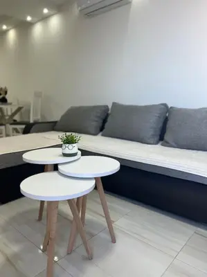 two tables in a living room with a couch at Studio apartman Gara in Kotor