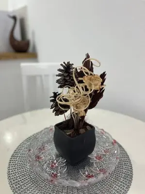 a black vase with flowers on a glass table at Studio apartman Gara in Kotor