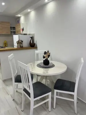 a white table with four chairs and a vase on it at Studio apartman Gara in Kotor